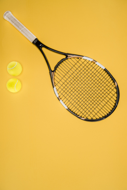 Tennis racket with balls isolated on yellow - Foto, Imagen