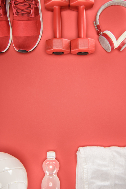 Equipamiento deportivo con zapatos, mancuernas, bola y auriculares aislados en rojo
 - Foto, Imagen