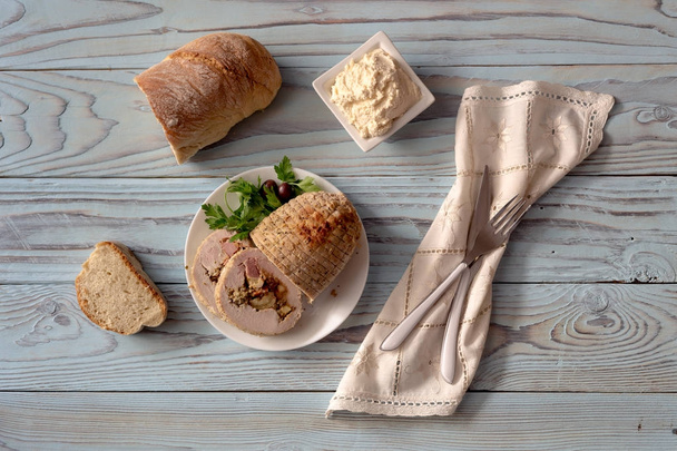 Roll kuřecí řízek s nádivkou, Jedlé kaštany, slaninu, sýr a koření je v talíři, na dřevěný stůl close-up (řecká kuchyně).  - Fotografie, Obrázek
