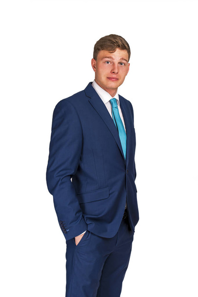 Бизнесмен в темно-синем костюме и руки в карманах, изолированные на белом фоне
. - Фото, изображение