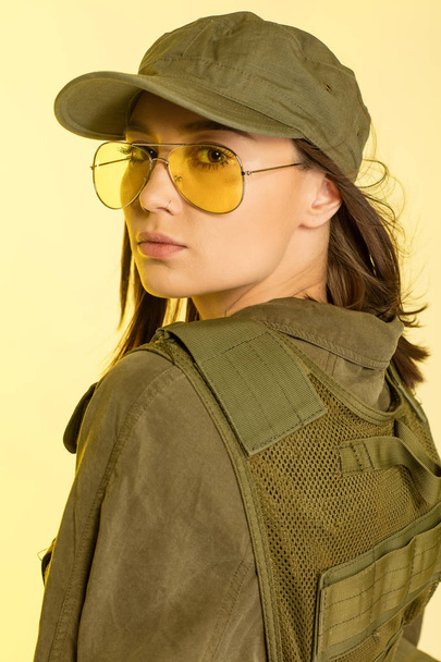 Sexy woman in soldier's suit on yellow background - Foto, Imagem