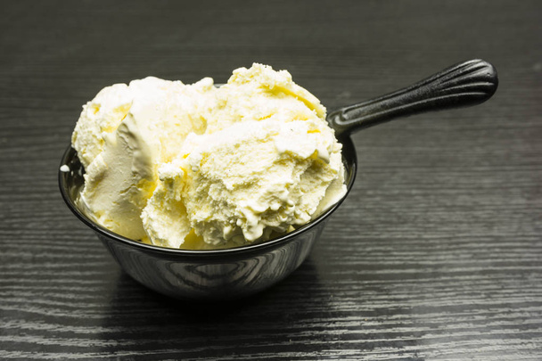 Vanilla ice cream in a black bowl. - Zdjęcie, obraz