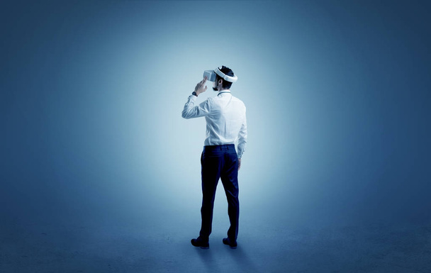 Businessman in an empty room with vr glasses - Foto, afbeelding