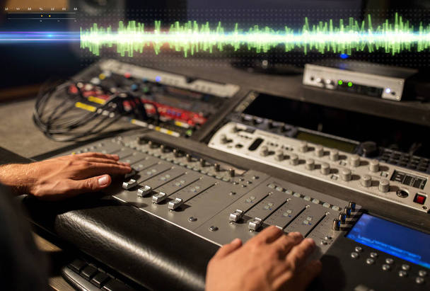 руки на микширующей консоли в студии звукозаписи
 - Фото, изображение