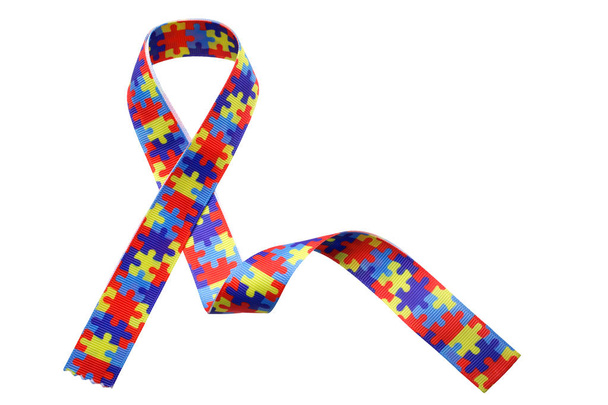 World Autism awareness and pride day with Puzzle pattern ribbon isolated on white - Foto, Bild