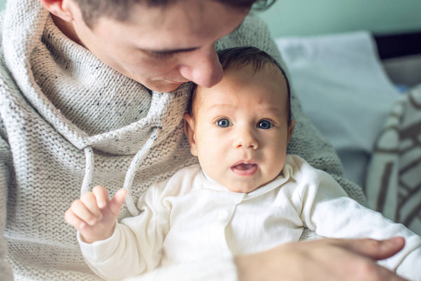Yatak odasında erkek bebek tutan mutlu bakım baba. Babalık ve aile değerleri hassasiyet kavramı - Fotoğraf, Görsel