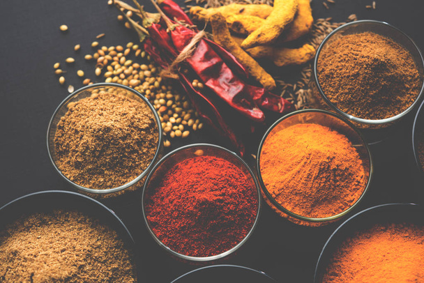 Indiaanse kleurrijke kruiden. Foto van de groep van vier fundamentele indiaanse kruiden zoals rauwe rode Spaanse peper, kurkuma, koriander en komijn poeder. selectieve aandacht - Foto, afbeelding