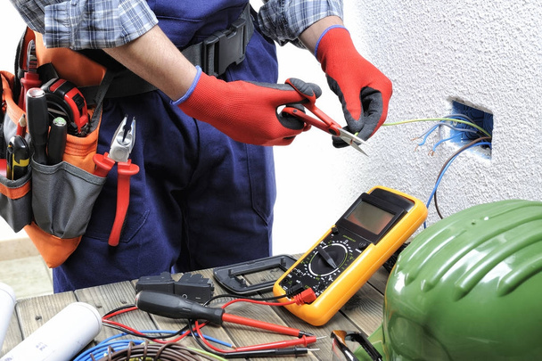Joven técnico electricista trabaja de acuerdo con personal de seguridad
 - Foto, Imagen