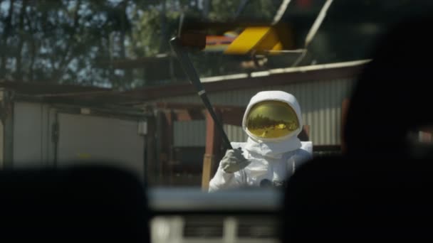4К Агрессивный астронавт с дорожной яростью приближается к машине размахивая бейсбольной битой
. - Кадры, видео