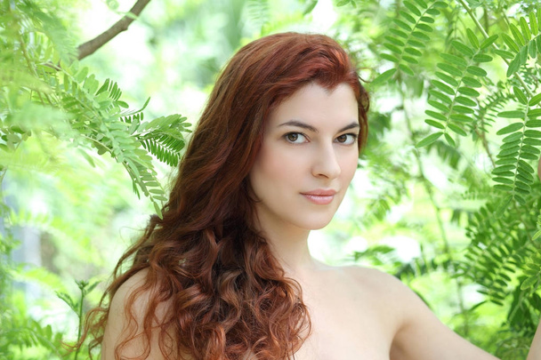緑の葉を持つ若い美しい女性の肖像画 - 写真・画像