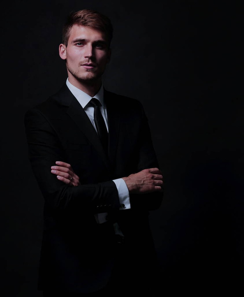 Happy business man wearing black suit standing and folding arms - Foto, afbeelding