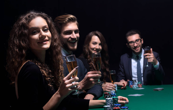 Poker players sitting around a table at a casino - Фото, изображение