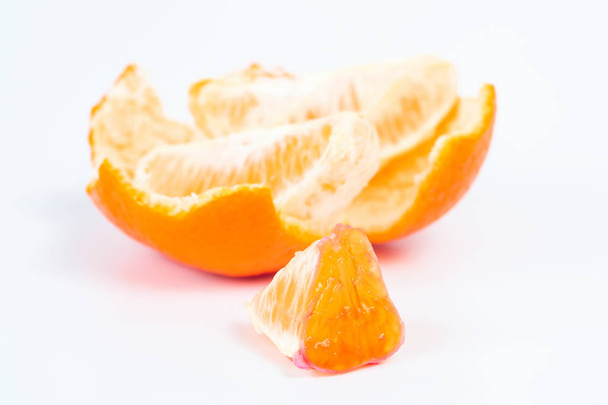 Un concepto de salud de frutas frescas de naranja peladas segmentos aislados sobre fondo blanco
 - Foto, Imagen