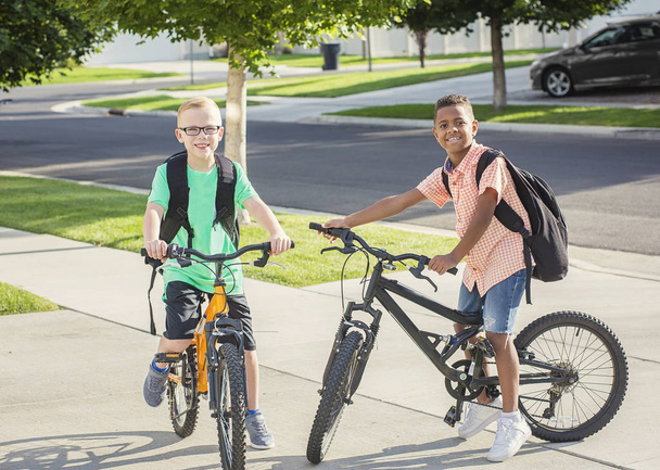 Két fiú ült a járdán kerékpárok - Fotó, kép