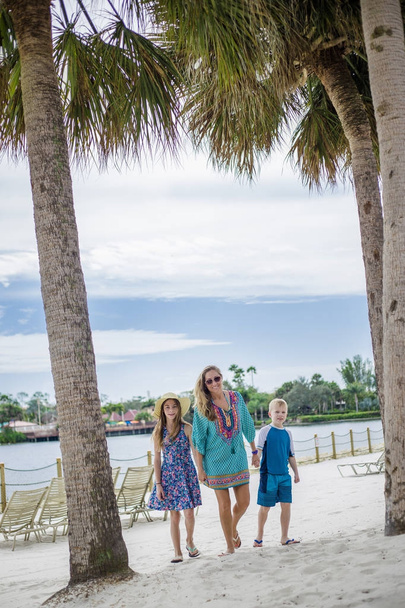Family walking together on a beach at a tropical beach resort - Photo, Image