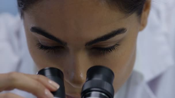 4K Extreme close up of medical researcher in the lab looking into microscope - Filmati, video