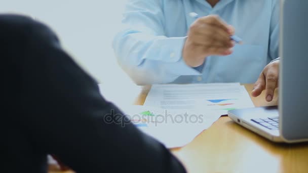 Business man and woman meeting and consult about business and marketing plan with infographic graph bar pi document on wooden table - Video