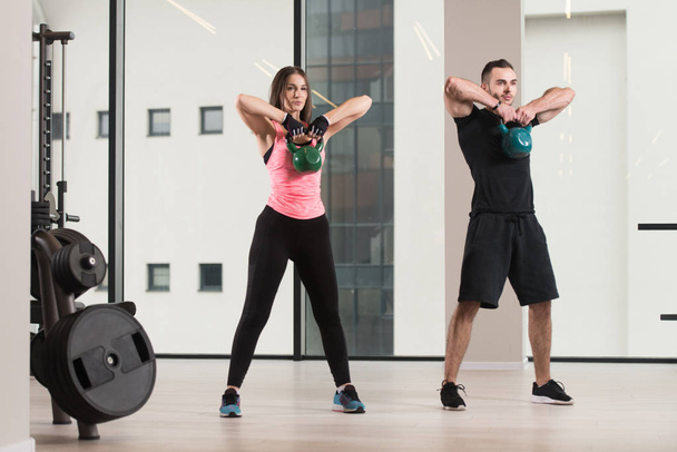 Fitness Woman And Man Working With Kettle Bell In A Gym - Kettle-bell Exercise - Photo, image