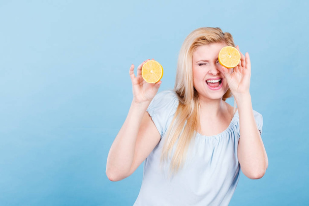 Girl covering her eyes with lemon citrus fruit - Фото, зображення