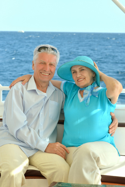 Glimlachend bejaarde echtpaar rust op jacht in zee - Foto, afbeelding