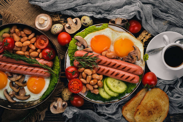English breakfast - fried egg, beans, tomatoes, mushrooms, bacon and toast. Top view. On a wooden background. - Foto, imagen