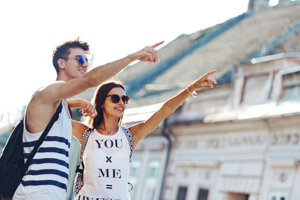 Two young tourists sightseeing a city, pointing with finger - Fotografie, Obrázek