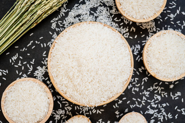 Raw Jasmine rice in wooden bowl  and spoon with grain and seed - Photo, Image