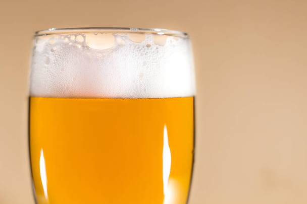 Beer in glass on brown background. - Foto, afbeelding