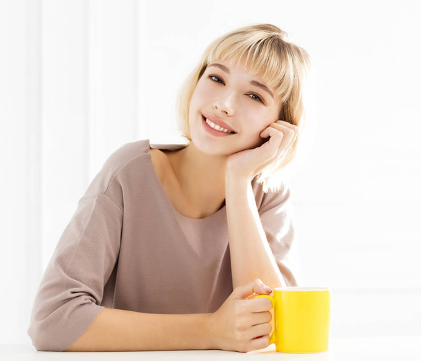Lachende vrouw koffie thuis genieten - Foto, afbeelding