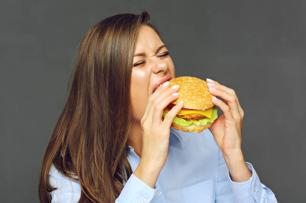 portré, fiatal, vonzó nő evés gyorsétterem burger  - Fotó, kép