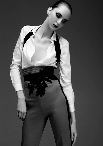 Fashion model wearing grey pants and white shirt - Fotó, kép
