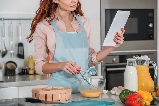 cropped image of woman looking at recipe for cooking  - Foto, imagen