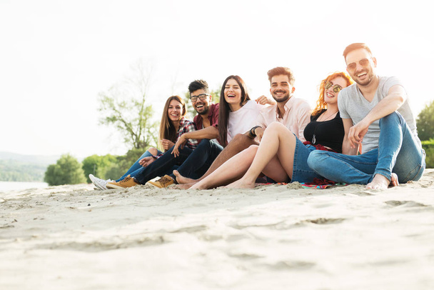 Group of young people having fun outdoors on the beach - Valokuva, kuva