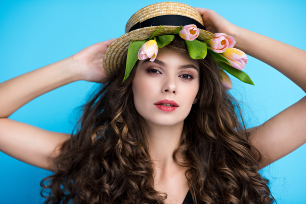 attractive young woman in canotier hat with pink tulips under it - Фото, изображение