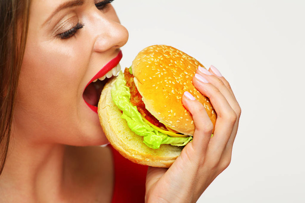 close-up portrait of woman face biting hamburger  - Foto, imagen