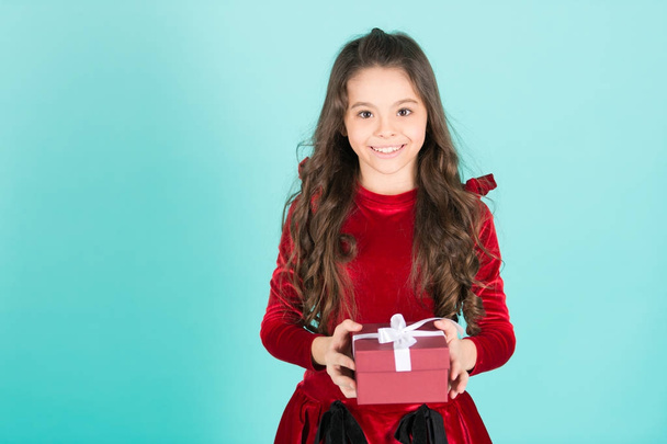 Happy child in red dress hold box on blue background - Φωτογραφία, εικόνα