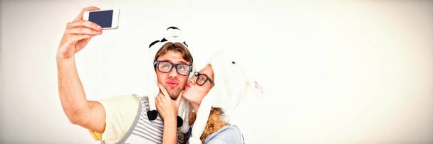 Geeky hipster couple taking selfie with smartphone on white background - Photo, Image