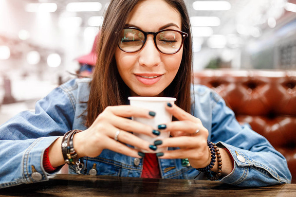 カフェでコーヒーを飲みながらスタイリッシュな女性 - 写真・画像