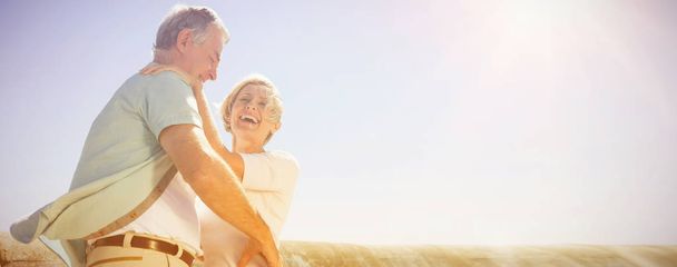 Senior woman hugging her partner on a sunny day - Фото, зображення