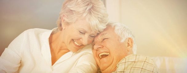 Cheerful senior couple laughing in bed at home - Foto, immagini