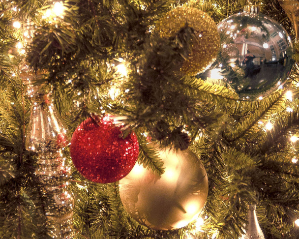 Yatay sıkı yakın çekim parlak ışıklar ve bu ilginç bir görüntü oluşturmak için ağaç dalları ile geleneksel bir Noel ağacı üzerinde asılı bir Noel süsler - Fotoğraf, Görsel