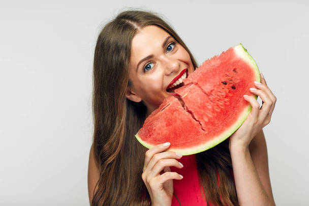 young woman wearing red dress eating watermelon - Фото, изображение
