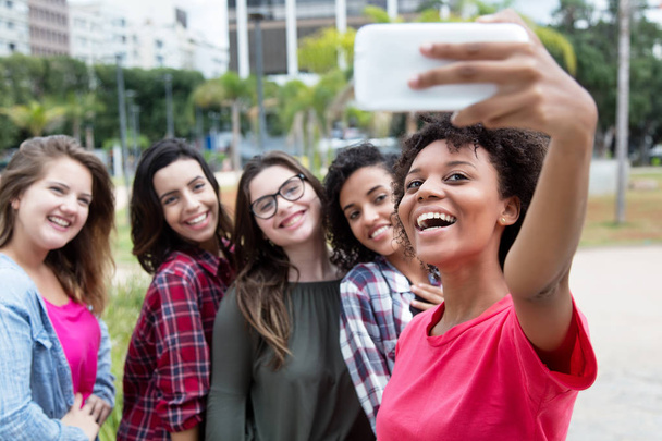 African american woman taking selfie with group of international - Foto, Bild