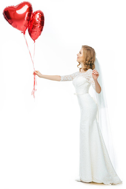 beautiful bride in wedding dress with heart shaped balloons isolated on white - Foto, Imagem
