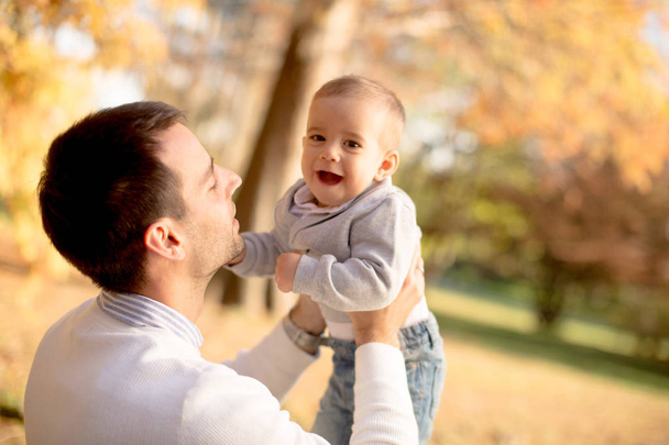 Νέος πατέρας και μωρό αγόρι στο πάρκο φθινόπωρο - Φωτογραφία, εικόνα