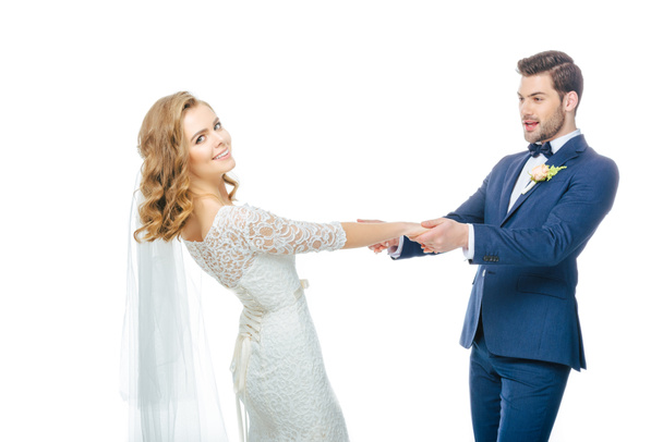 schönes Hochzeitspaar Händchen haltend beim gemeinsamen Tanzen isoliert auf Weiß - Foto, Bild