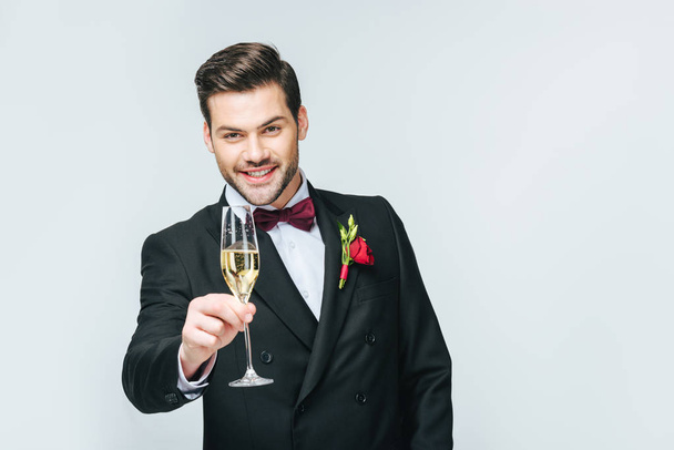 portrait of smiling man with glass of champagne isolated on grey - Photo, image