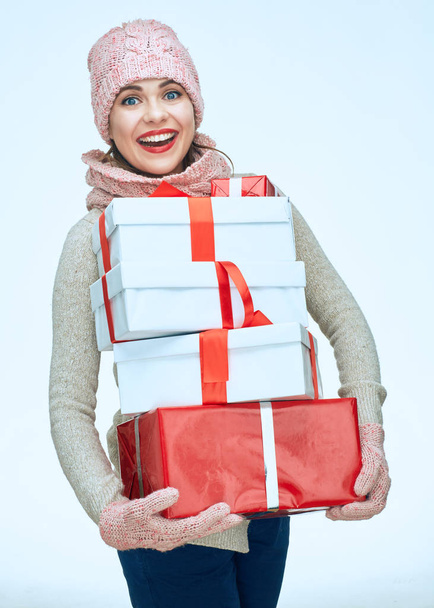 happy woman in winter warm clothes holding white and red gifts  - Fotoğraf, Görsel