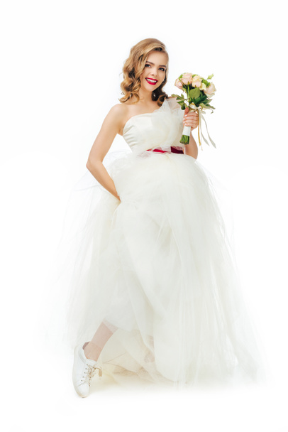 smiling bride in beautiful wedding dress with flowers in hand isolated on white - Photo, image
