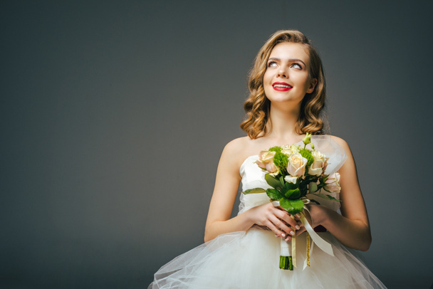 portrait of beautiful pensive bride with wedding bouquet looking away - Foto, Imagem